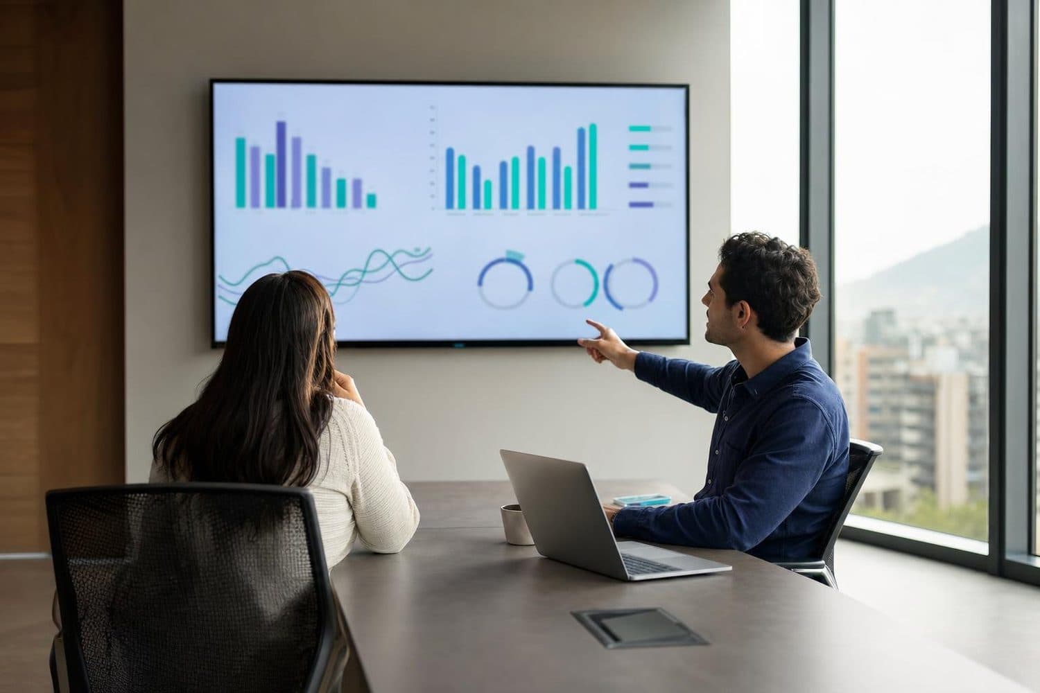 Dos profesionales analizan un tablero de Business Intelligence en una pantalla